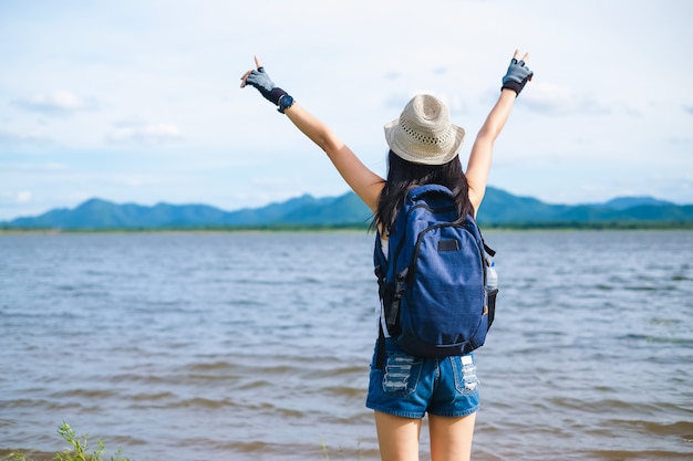 woman traveler standing near the lake background is the mountain