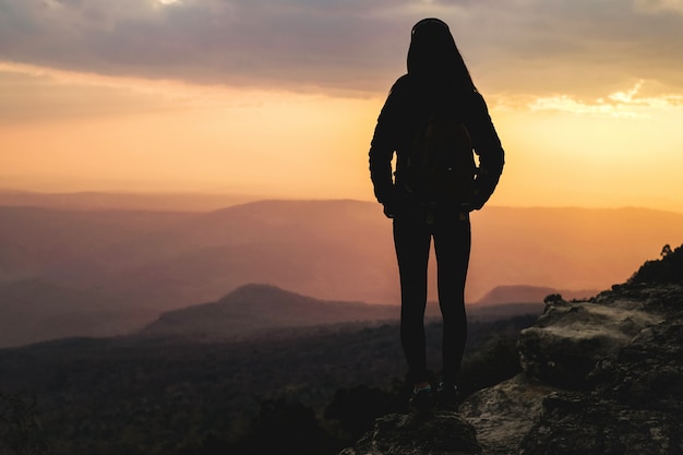 写真 山の上に立って、休日に自然の写真を撮る女性旅行者。