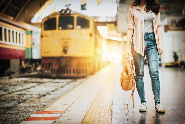 女性の旅行者、駅に立つ