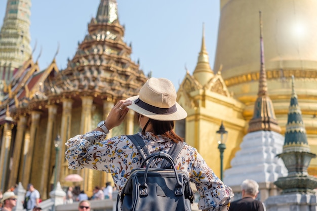  Woman traveler standing at Wat Phra Kaew temple, landmark for tourist attractions 