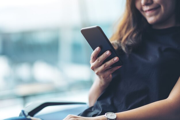 Una viaggiatrice che usa il cellulare mentre è seduta in aeroporto