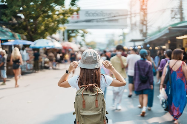 Donna che viaggia in visita a bangkok turista con zaino e cappello che fa un giro turistico nel punto di riferimento del mercato del fine settimana di chatuchak e attrazioni popolari a bangkok thailandia viaggio nel concetto di sud-est asiatico