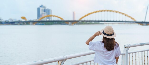 다낭시를 방문하는 여성 여행자 관광객은 드래곤 브릿지 랜드마크와 베트남 및 동남아시아 여행 컨셉으로 인기 있는 강 전망을 관광합니다.