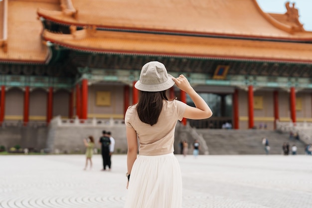 Woman traveler visiting in Taiwan Tourist with hat sightseeing in National Chiang Kai shek Memorial or Hall Freedom Square Taipei City landmark and popular attractions Asia Travel concept