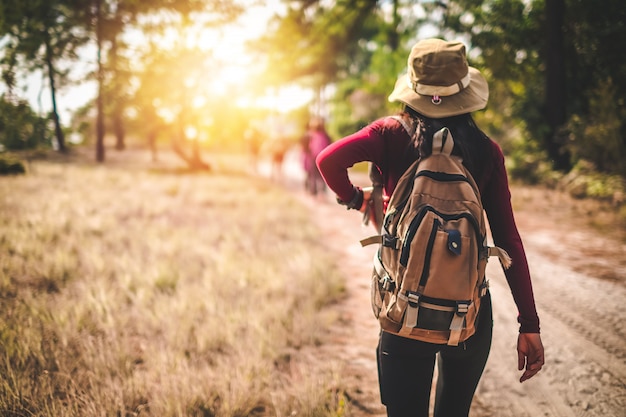 写真 森を歩くと休日に自然の美しい景色を楽しんでいる女性旅行者。冒険のコンセプト。