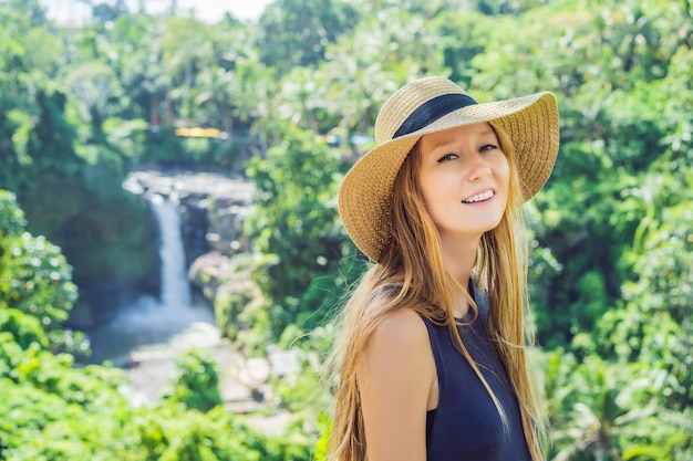 Woman traveler on a waterfall background Ecotourism concept