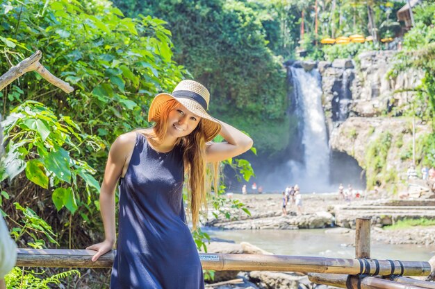 Woman traveler on a waterfall background Ecotourism concept