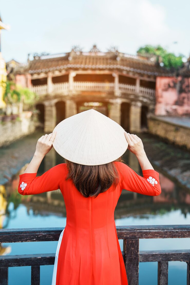 Photo アオザイ ベトナム ドレスを着た女性旅行者ホイアン町ベトナム ランドマークと観光スポット ベトナムと東南アジア旅行の概念で人気の日本の屋根付き橋で観光