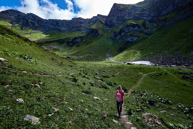 美しい山の谷の風景にバックパックを持った女性旅行者。