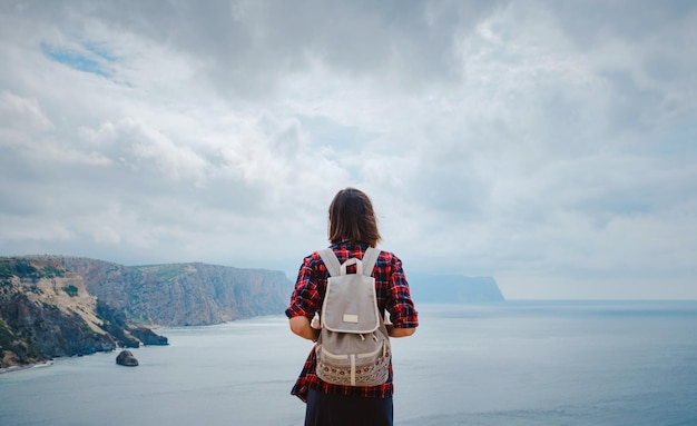 写真 夏の海岸でバックパック観光客と一緒に旅行する女性