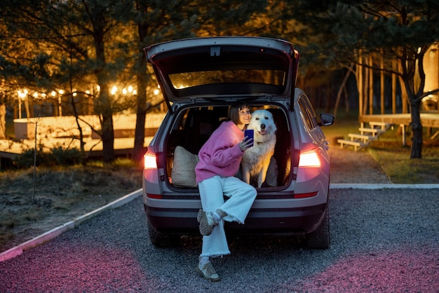 Woman traveling with a dog by car on nature