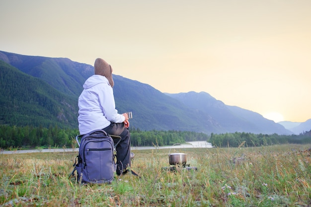 Woman traveller sitting and enjoying hot tea in a mug.