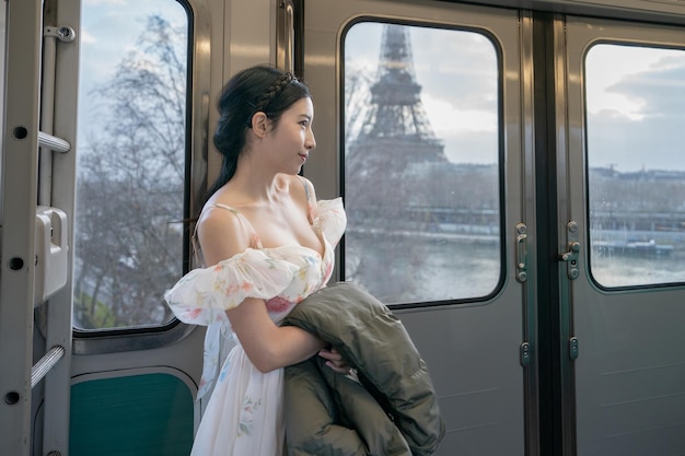 Woman travelling in a train and looking through the window at the Eiffel tower