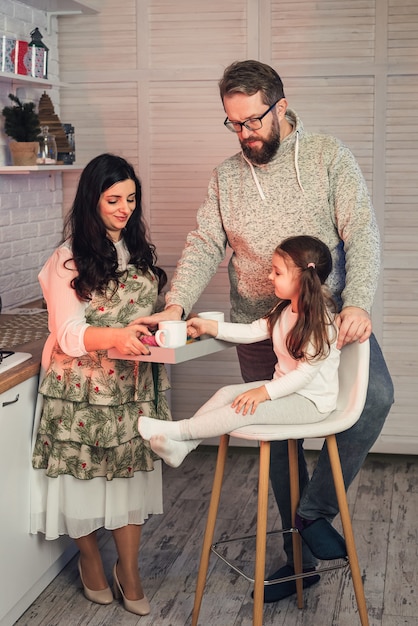 A woman treats her daughter and husband to tea