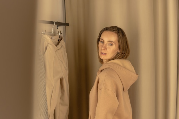 Woman trying on casual suit in a fitting room of a clothing store