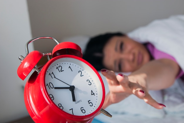 Woman turning off the alarm clock