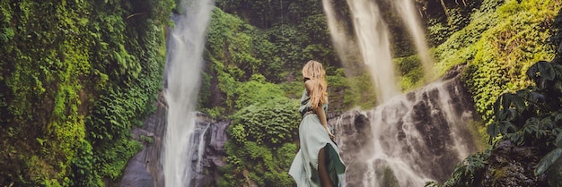 Woman in turquoise dress at the sekumpul waterfalls in jungles
on bali island indonesia bali travel