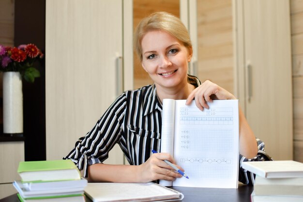 Woman tutor webcam Teacher with book in front of laptop