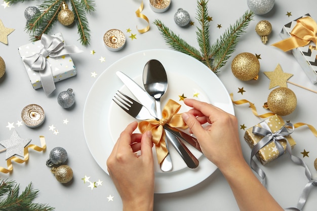 Woman tying a bow on New year table setting