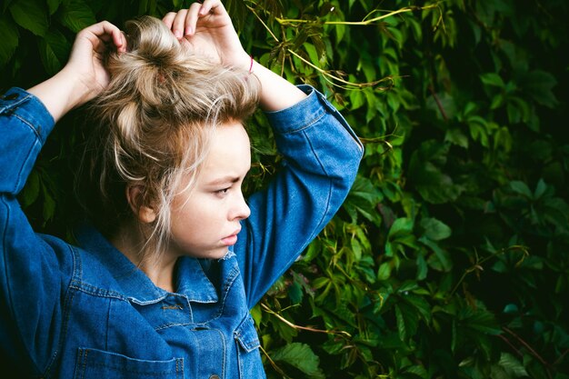 Woman tying hair against plants