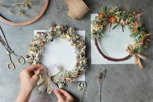 Woman tying a ribbon on a floral wreath