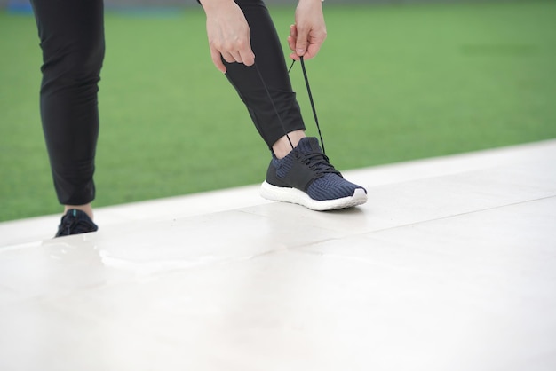 Woman tying shoe before running