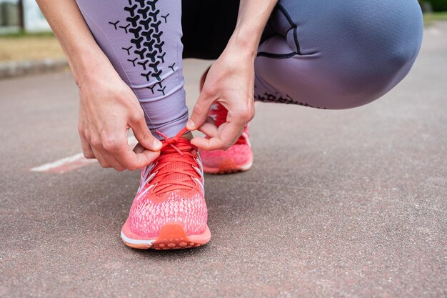 Foto donna che lega i lacci delle scarpe per fare jogging lacci delle sneakers con legatura piatta chiusa