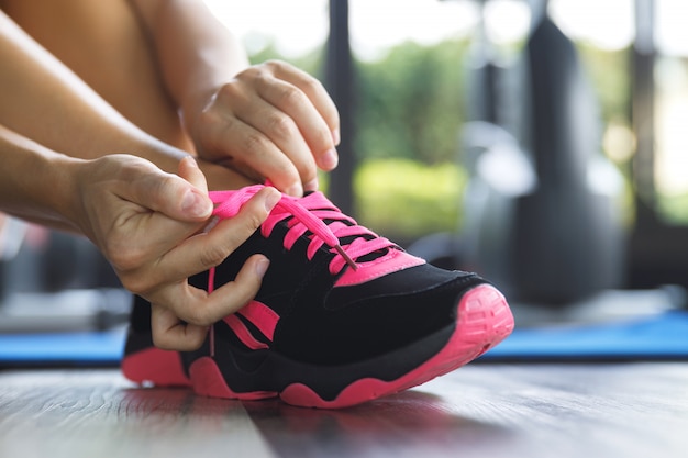 Woman tying shoelaces of her sneakers