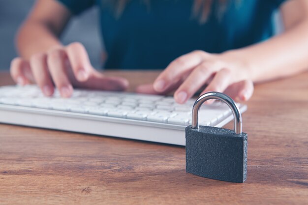 Photo woman typing on the keyboard next to the lock