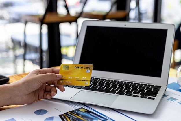 A woman typing on a laptop keyboard, she is filling out her credit card information to pay for an order on an Internet shopping site. Online shopping and credit card payment concept.