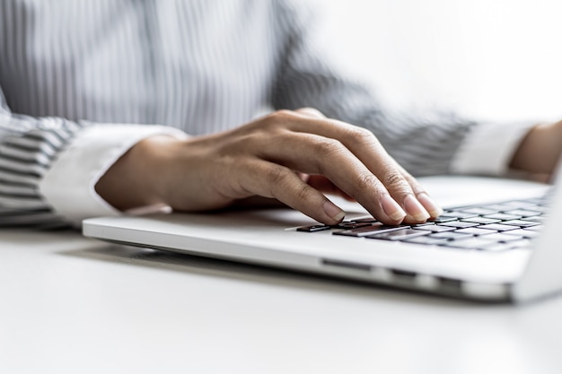 A woman typing on a laptop keyboard, she is filling out her credit card information to pay for an order on an Internet shopping site. Online shopping and credit card payment concept.