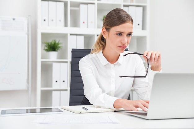 Woman typing at laptop keyboard