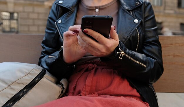 Woman typing message on city street showcases concept of social media in everyday life