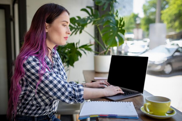 Женщина печатает на ноутбуке с пустым экраном с копией пространства для текста или рекламного контента, сидит ...
