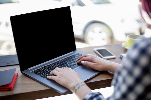 Женщина печатает на ноутбуке с пустым экраном с копией пространства для текста или рекламного контента, сидит ...