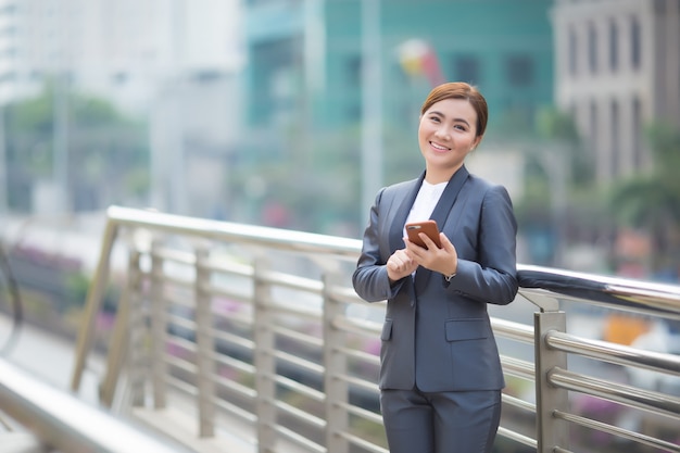 スマートフォンを入力する女性と彼女は幸せを感じる