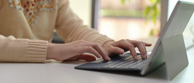 Woman typing on tablet computer