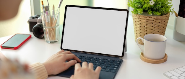 Woman typing on tablet computer