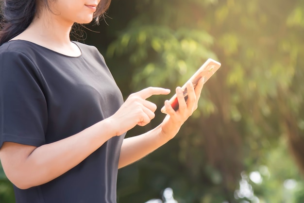 Woman typing text message on smart phone.Young woman outdoors on cell phone.