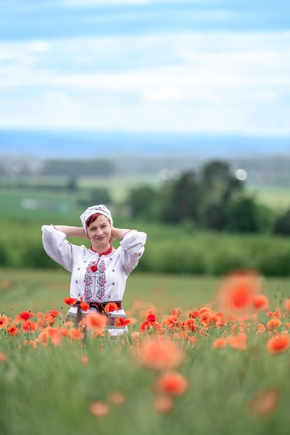 Женщина в украинском национальном костюме на цветущем маковом поле