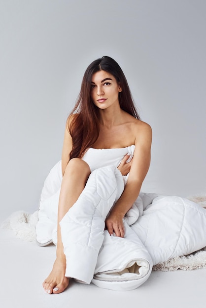 Woman in underwear in the studio against white background.