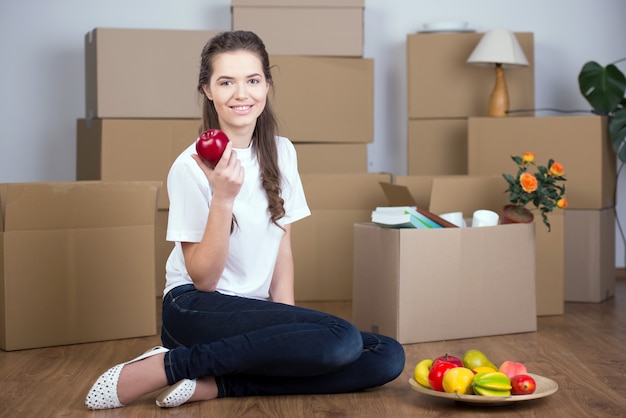 Woman unpacking boxes in living room.