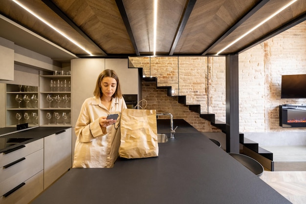 Woman unpacking groceries at modern kitchen