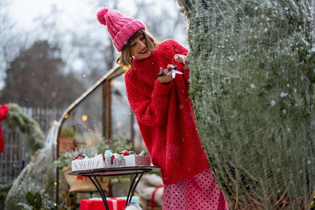 女性は裏庭でクリスマス ツリーを開梱します。