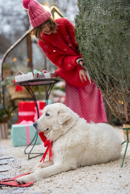 女性は裏庭でクリスマス ツリーを開梱します。