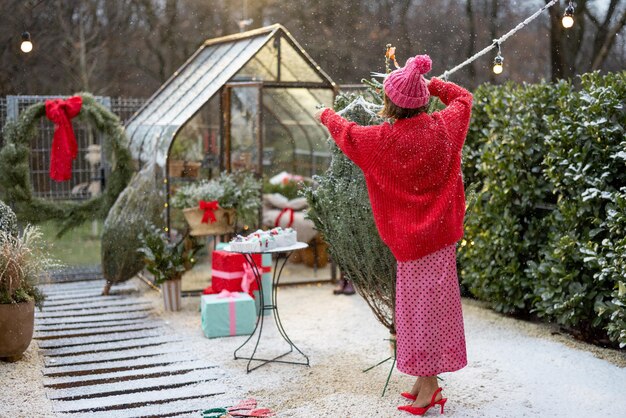 Woman unpacks christmas tree at backyard