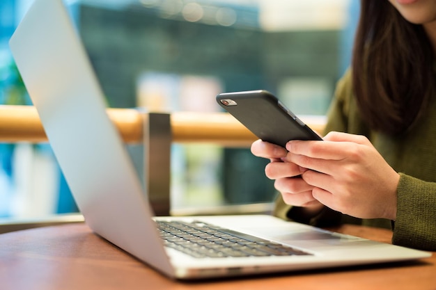 Woman use of cellphone with her computer