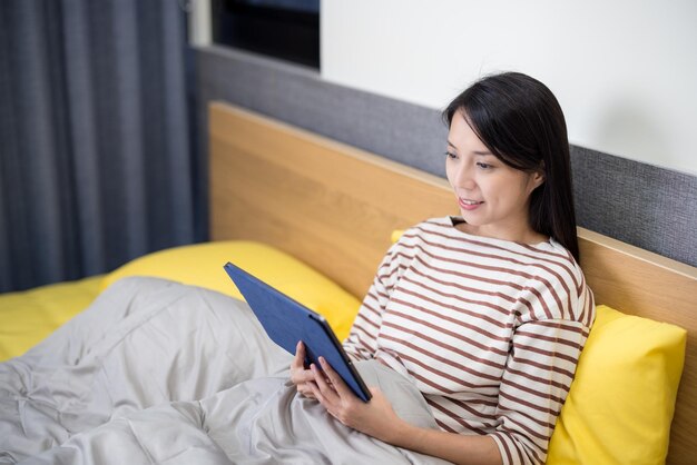 Woman use digital tablet on bed