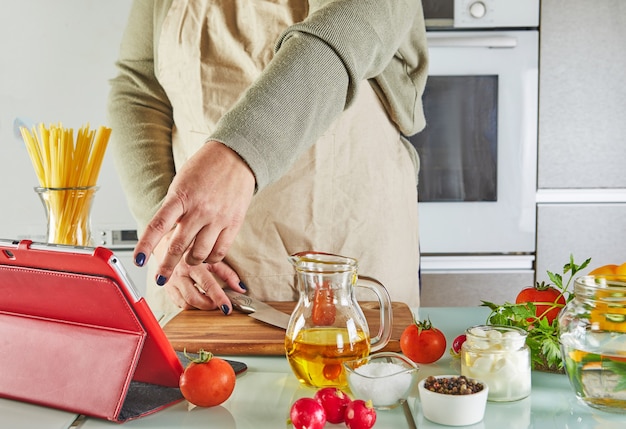 Woman use finger slide on tablet screen cooking according the tutorial of online virtual master class