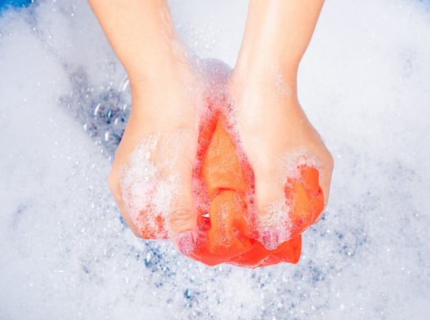 woman use hands washing color clothes in basin with detergent have soapy bubble water